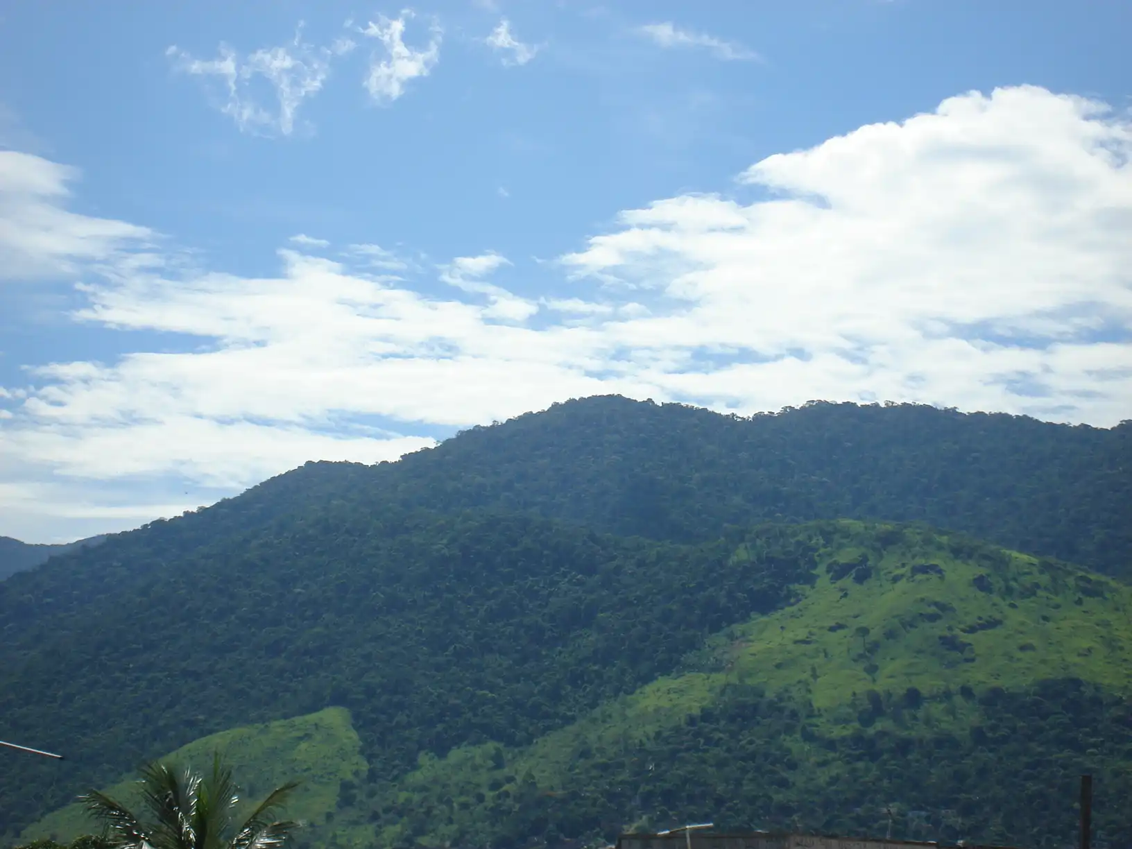 Serra do Gericinó vista de Nilópolis, na Baixada Fluminense, com mata verde e céu azul