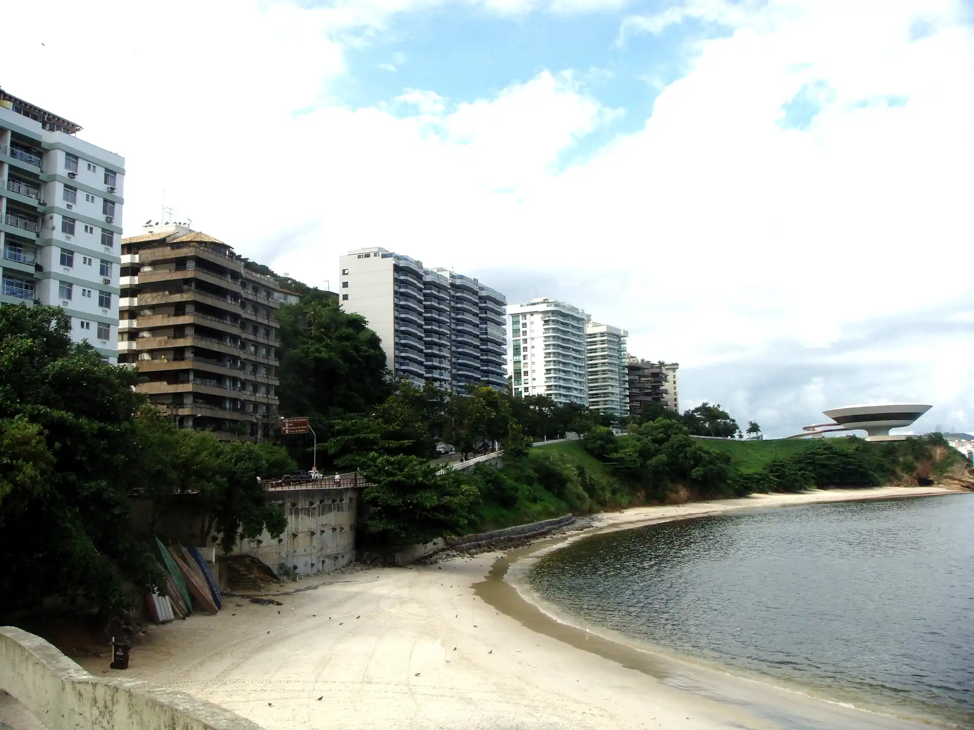 Praia da Boa Viagem, em Niterói, com prédios à beira-mar e o Museu de Arte Contemporânea ao fundo