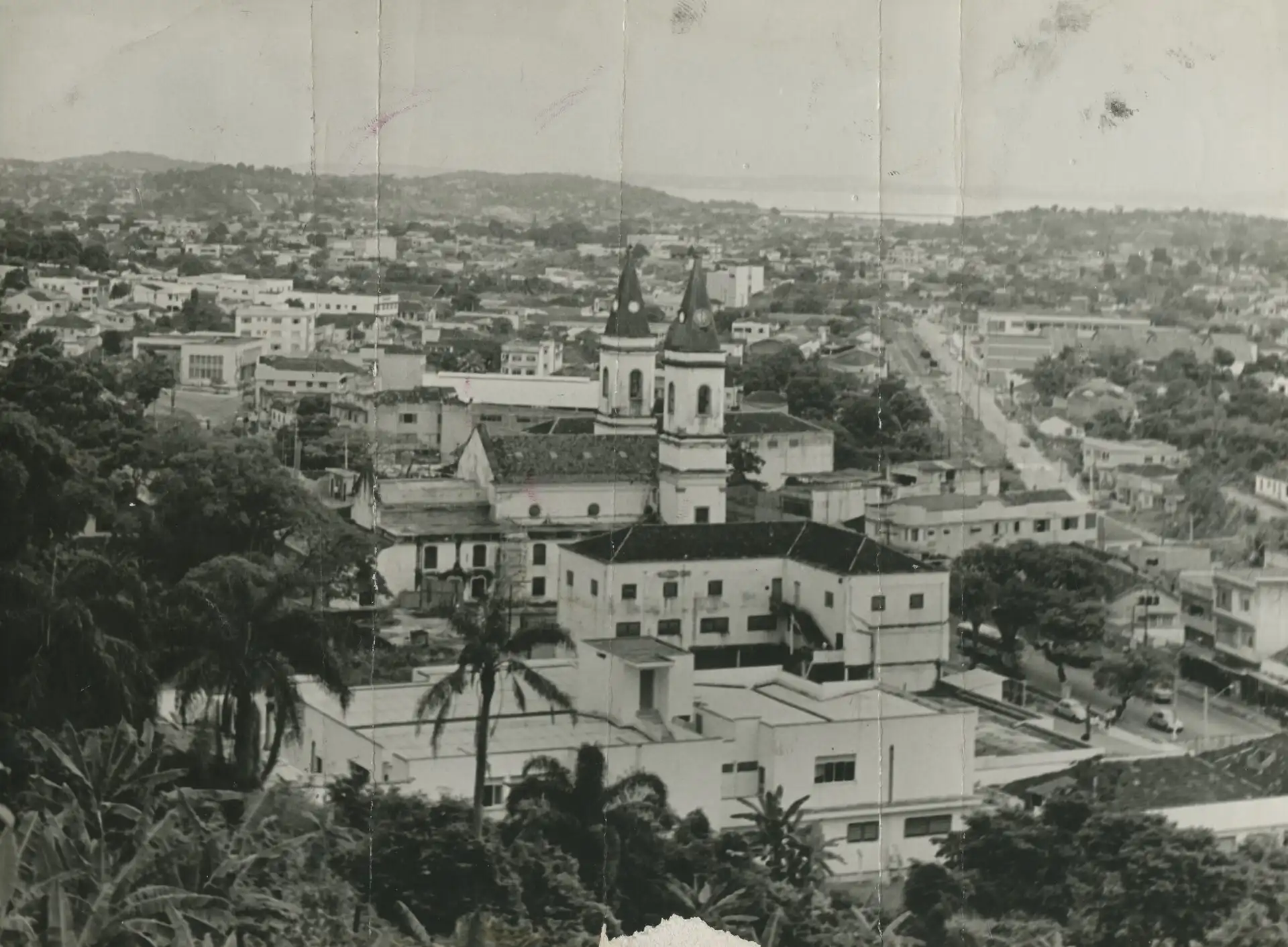 Foto histórica em preto e branco de São Gonçalo vista do alto, com uma igreja e o casario da cidade